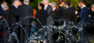 Blurred people in black suits on funeral